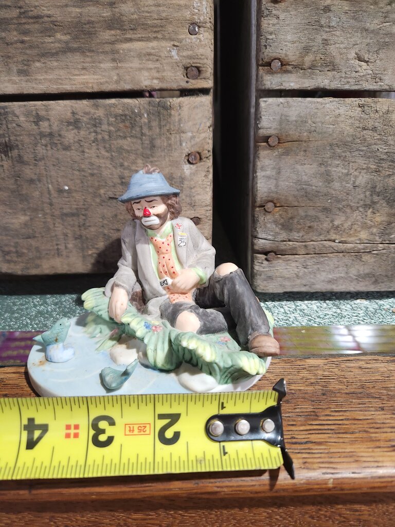 Clown Figurine Sitting on Grass with Birds